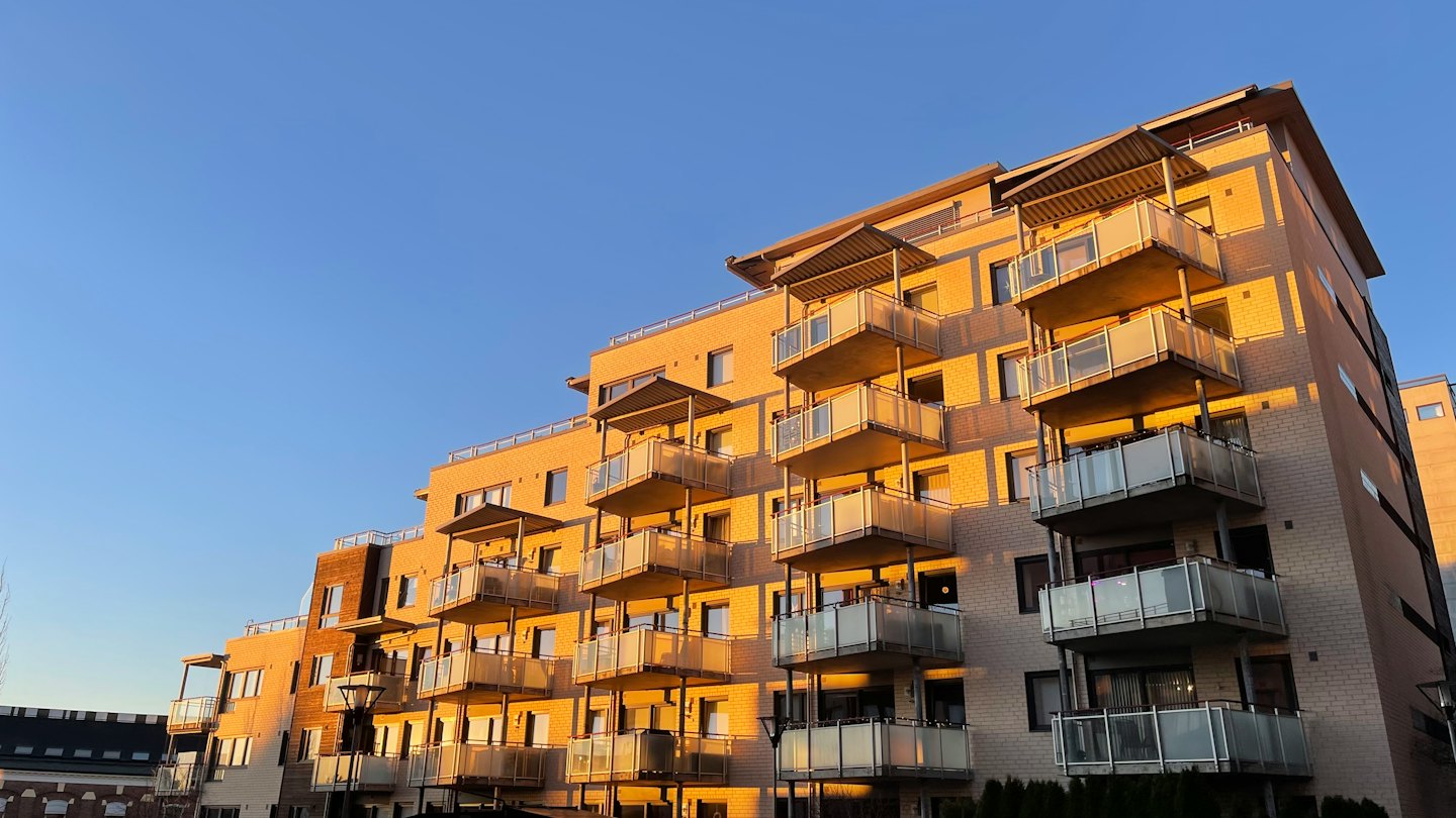 Palazzo con balconi illuminato dalla luce dorata del tramonto.